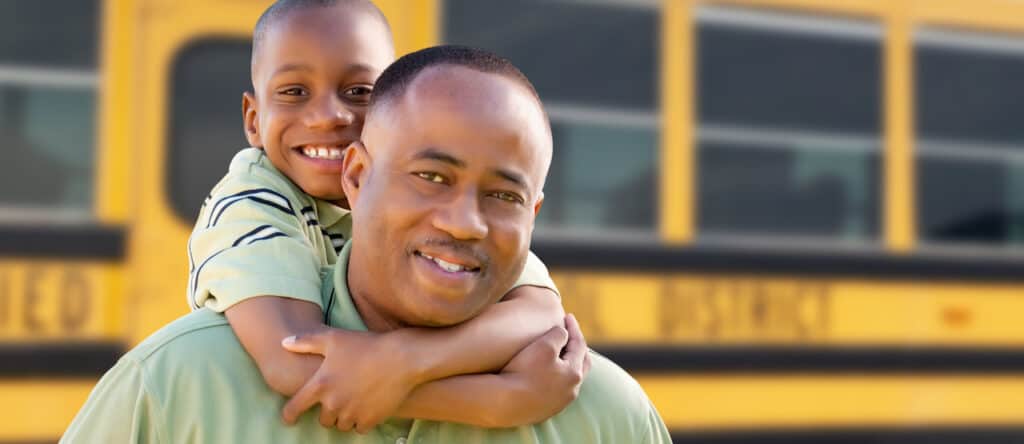 Father and son by school bus