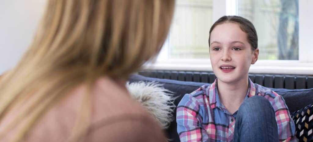 Teen girl with mom having conversation at home