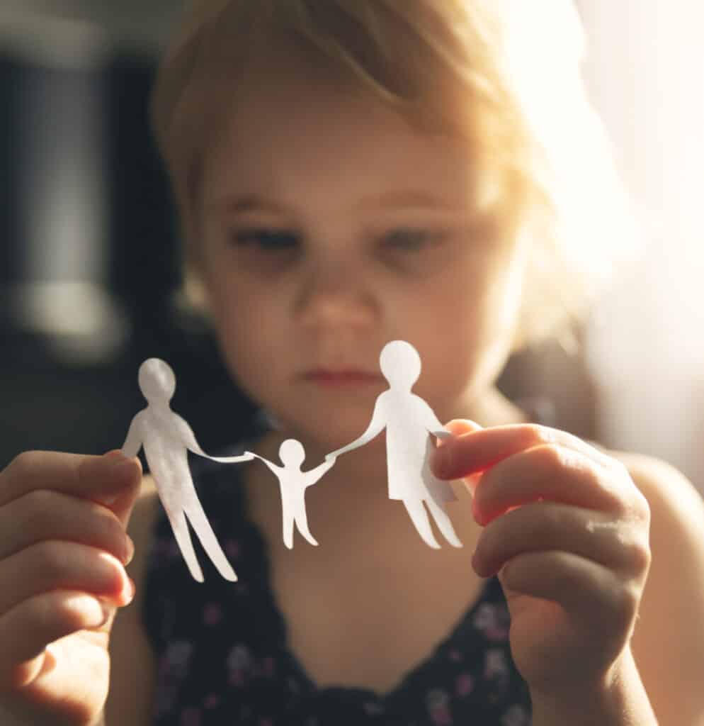 Young girl holding a paper cutout of a family