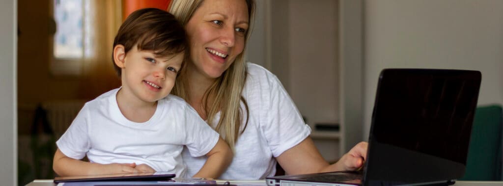 Mom and son at the table using a Chromebook and iPad.