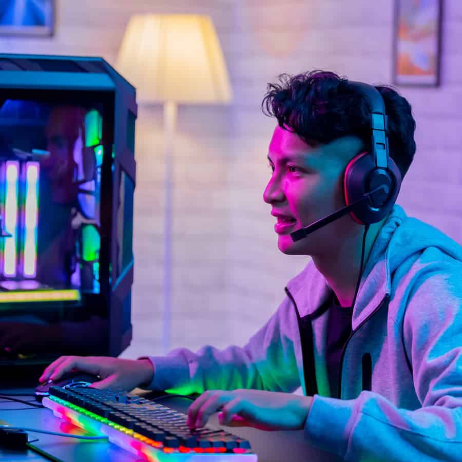 Teenage boy sitting at a PC playing games.