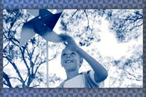 A boy plays with a pinwheel outdoors